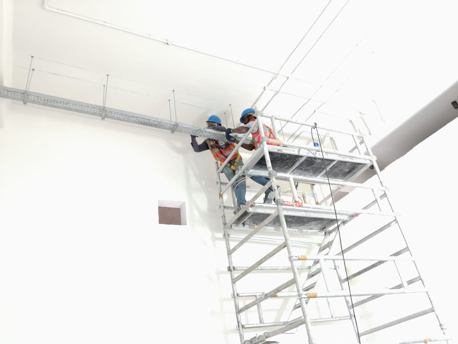 A technician installing a cable tray in a Airport